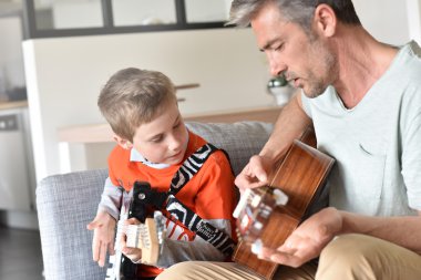 Baba oğluyla gitar çalmaya