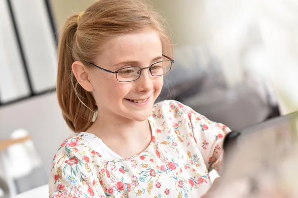 Adolescente con anteojos usando tableta — Foto de Stock