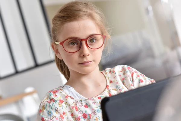 Adolescente con anteojos usando tableta — Foto de Stock