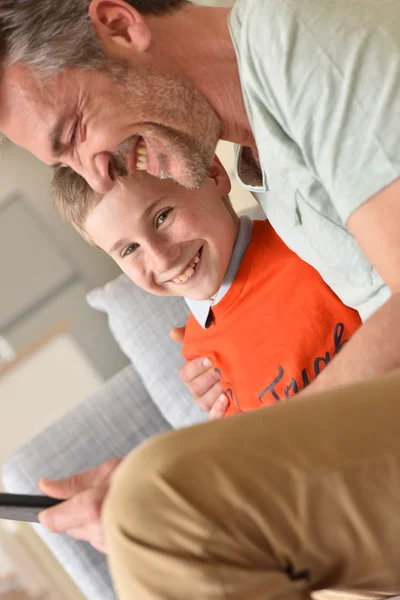 Хлопчик грає на цифровому планшеті з татом — стокове фото