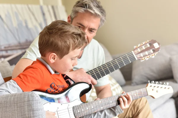 Papi con hijo tocando guitarras Imágenes De Stock Sin Royalties Gratis