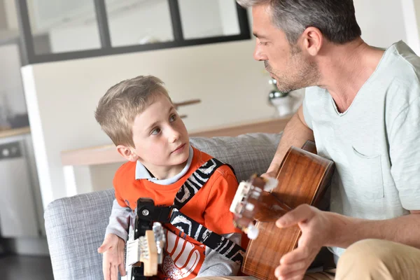 Papa und Sohn spielen Gitarre lizenzfreie Stockbilder