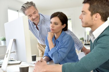  masaüstü bilgisayarda çalışan insanlar