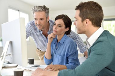  masaüstü bilgisayarda çalışan insanlar