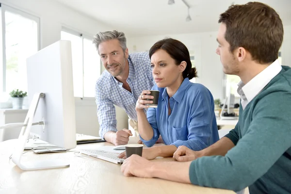  masaüstü bilgisayarda çalışan insanlar