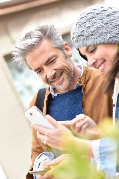 Couple in town using smartphone — Stock Photo, Image
