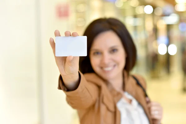 Woman holding card in shopping mall — Stock Photo, Image