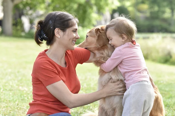 Femme et bébé fille étreignant chien — Photo