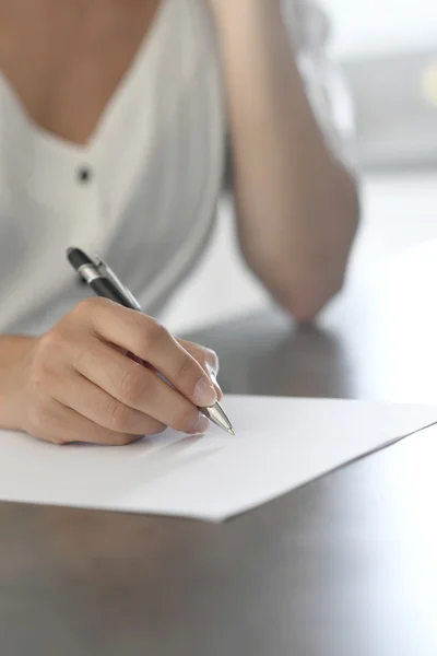 Escritura de la mano de la mujer en papel Imagen De Stock