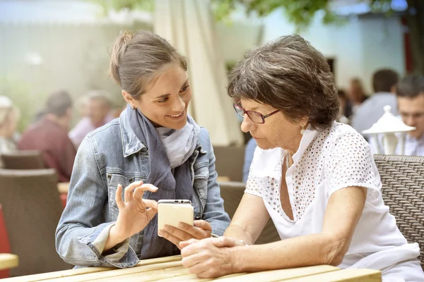 Woman and home carer  using smartphone — Stock Photo, Image