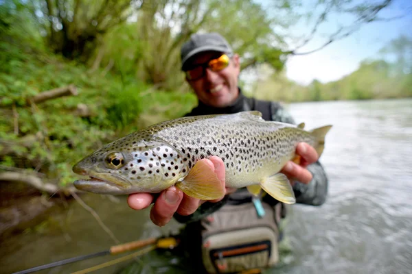 Gelukkig fly-fisherman bedrijf forel — Stockfoto