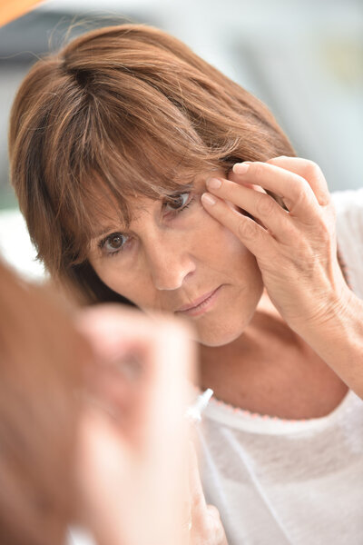  Женщина наносит глазной консилер
