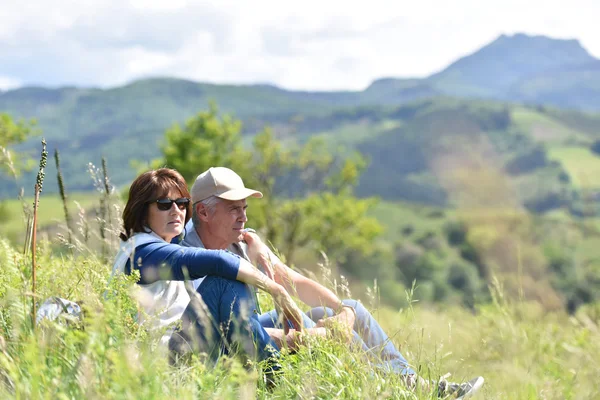 Coppia di escursionisti seduti in erba — Foto Stock