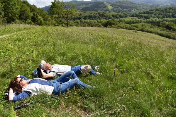 Mature couple relaxing on field — Stock Photo, Image