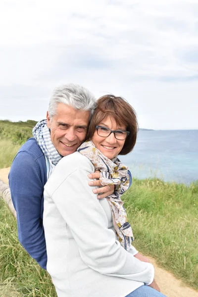 Paar sitzt an Klippe — Stockfoto