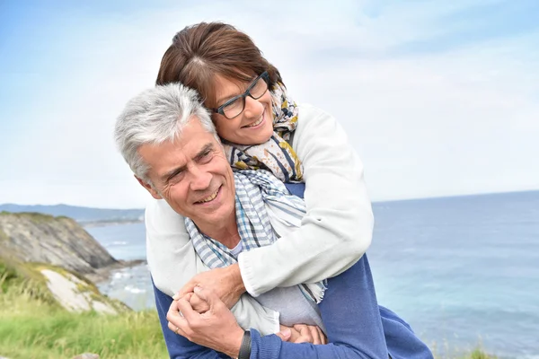 Homem dando piggyback passeio para mulher — Fotografia de Stock