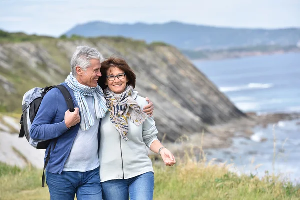 Paar wandelen door zeeklip — Stockfoto