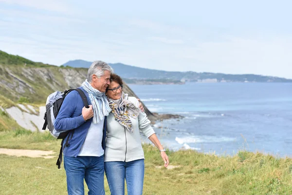 Couple walking by sea cliff — Stock Photo, Image