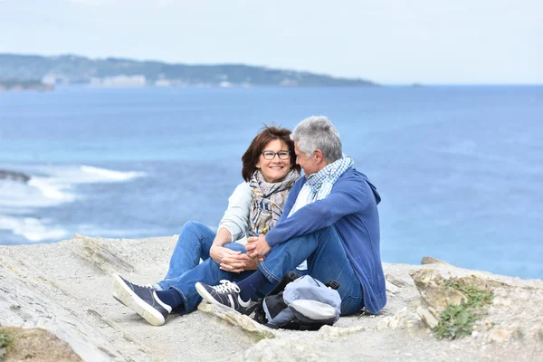 Casal sentado por penhasco — Fotografia de Stock