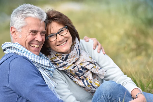 Madura casal sentado na grama — Fotografia de Stock