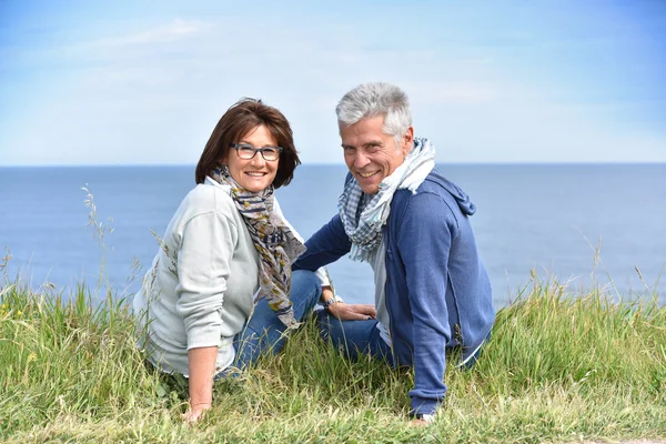 Casal sentado por penhasco — Fotografia de Stock