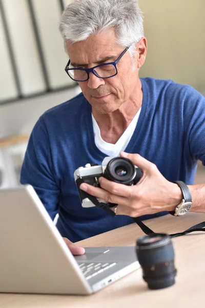 Человек загружает фотографии на ноутбук — стоковое фото