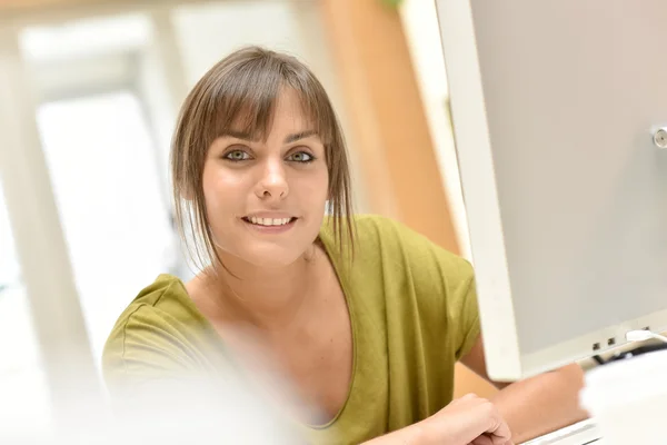 Büroangestellte sitzt am Schreibtisch — Stockfoto