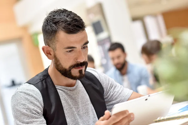 Empresário no escritório trabalhando em tablet — Fotografia de Stock