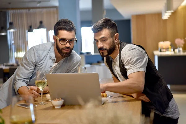 Chicos en el bar conectado con el ordenador portátil — Foto de Stock