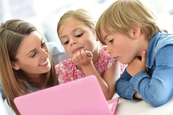 Barn med mamma leker på laptop — Stockfoto