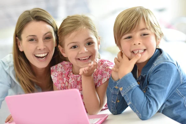 Дети с мамой играют на ноутбуке — стоковое фото