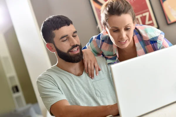 Paar schaut sich Webseite auf Laptop an — Stockfoto