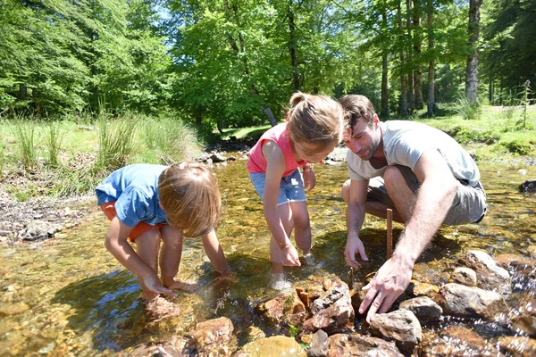 Far och barn bygga en damm — Stockfoto