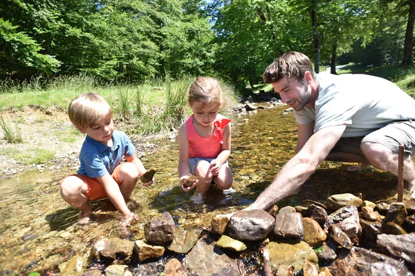 Vader en kinderen bouw van een dam — Stockfoto