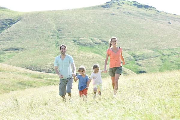 Familia corriendo por la colina — Foto de Stock