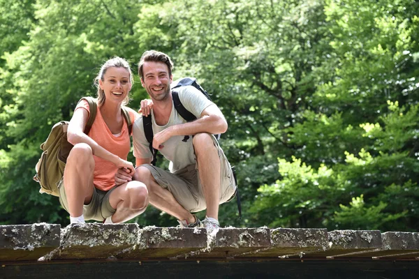 Randonneurs agenouillés sur un pont — Photo