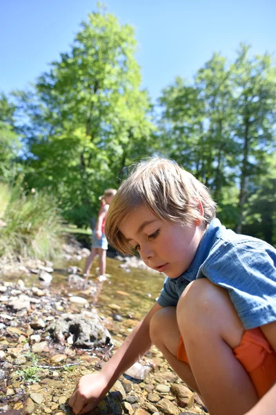 Junge sucht Kaulquappen im Fluss — Stockfoto