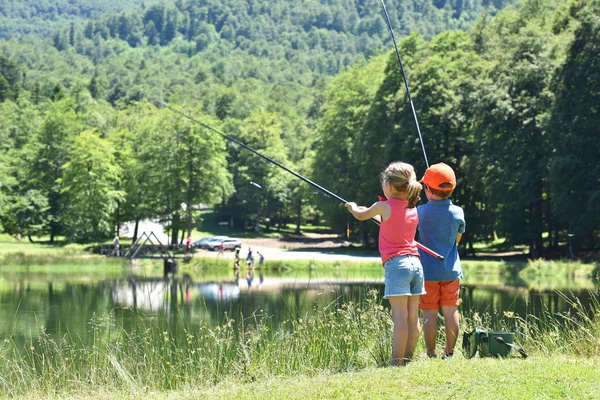 Pêche des enfants par lac de montagne — Photo