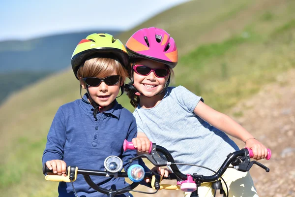 Glada barn ridning cyklar — Stockfoto