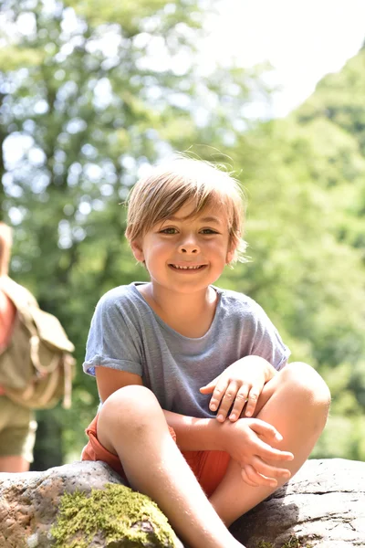 Carino bambino seduto su roccia — Foto Stock