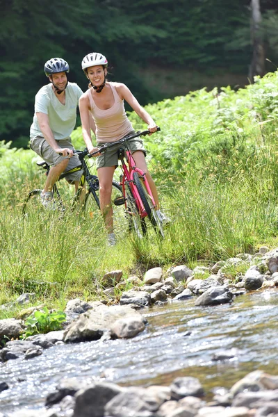 Couple crossing river stream — Stock Photo, Image