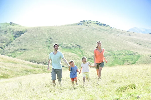 Famiglia correre giù per la collina — Foto Stock