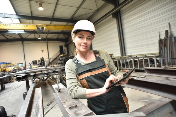 Kvinna i fabrik med surfplatta — Stockfoto