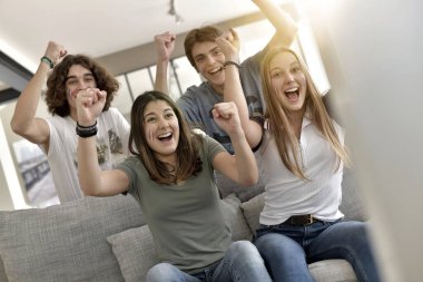 Bir grup arkadaş TV 'de maç izlerken neşeleniyor