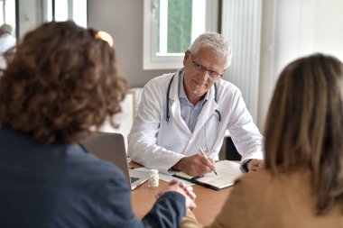 Doktor muayenehanesinde randevusu olan genç bir çift.