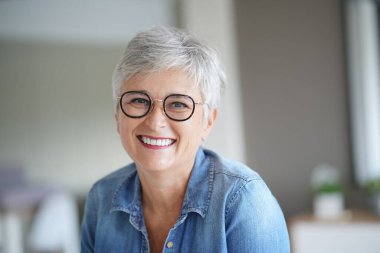 50 yaşında güzel gülümseyen beyaz saçlı bir kadının portresi.