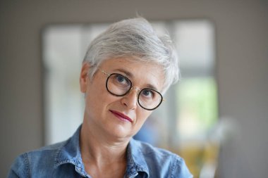 50 yaşında güzel gülümseyen beyaz saçlı bir kadının portresi.