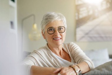 55 yaşında güzel gülümseyen beyaz saçlı bir kadının portresi.