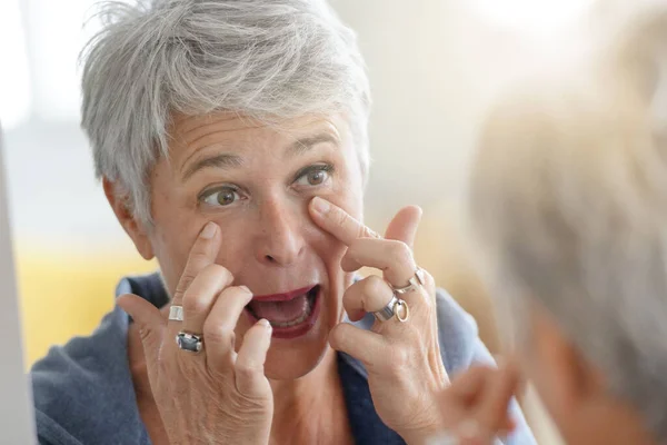Madura Mujer Pelo Blanco Comprobar Las Arrugas Los Ojos Delante — Foto de Stock