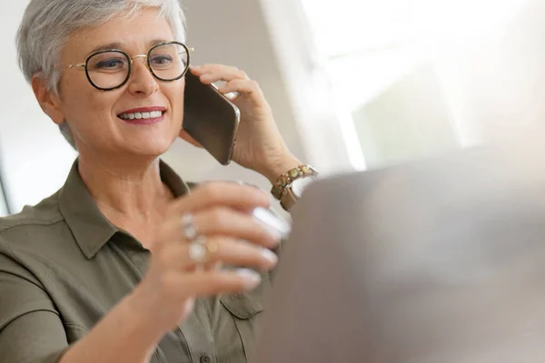 Ελκυστική Ηλικιωμένη Γυναίκα Μιλάει Στο Τηλέφωνο Στο Γραφείο — Φωτογραφία Αρχείου